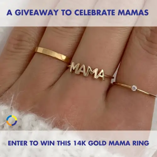 Image of a hand wearing three rings: a plain gold band, a ring with the word "mama" in cursive, and a simple diamond ring.