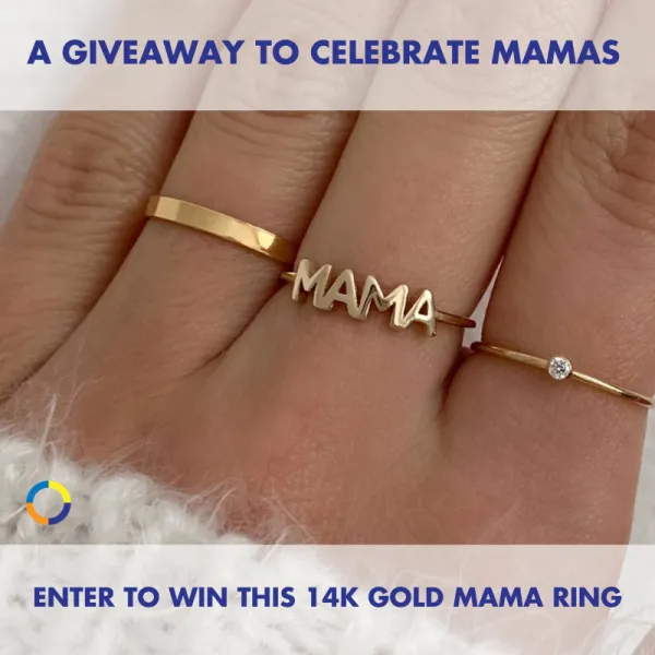 Image of a hand wearing three rings: a plain gold band, a ring with the word "mama" in cursive, and a simple diamond ring.